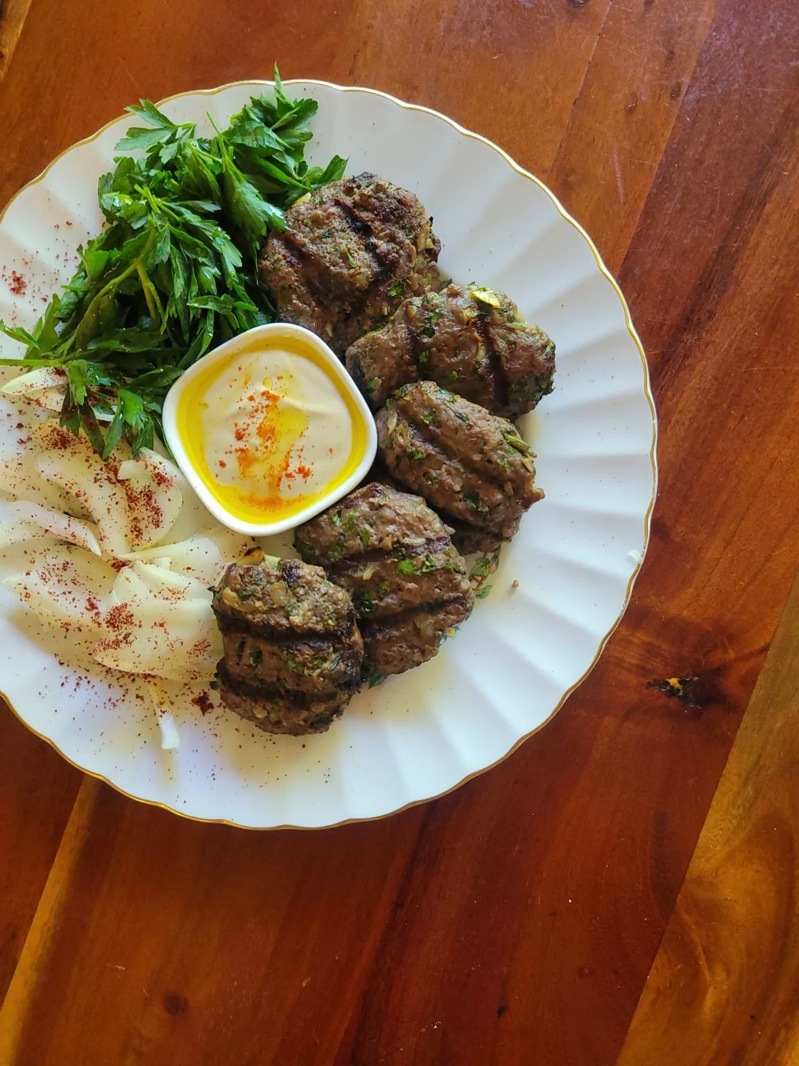 Beautifully plated meat with fresh herbs and sauce